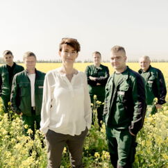 Bio-Planéte Gründerin Judtih Moog mit Bio Landwirten auf einem blühenden Rapsfeld