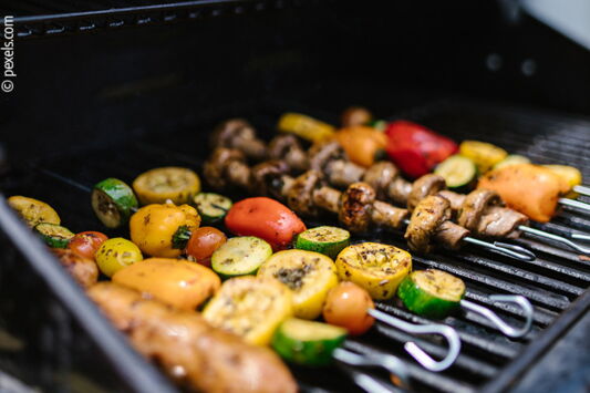 Grill-Spieße mit Gemüse liegen auf einem Grill