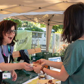 Regionale Lieferantin auf dem Regionalfest spricht mit Besucherin
