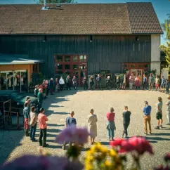 Menschen stehen in einem Kreis auf dem Hofgelände von Mahlitzsch
