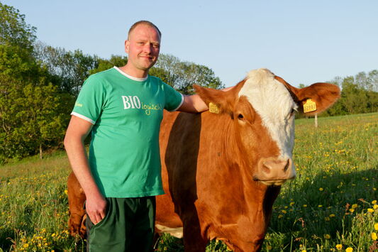 Stefan Klemm mit einer Kuh auf der Weide