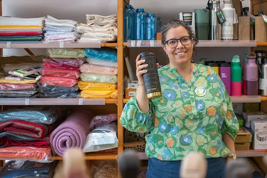 Mitarbeiterin im Naturwarenladen Dresden hält einen Kaffeebecher von Klean Kanteen