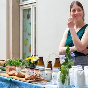 Frau steht an einem Stand mit Bio-Produkten zum Probieren