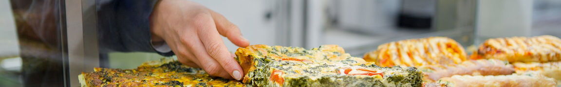 Hand greift Quiche und Pizza