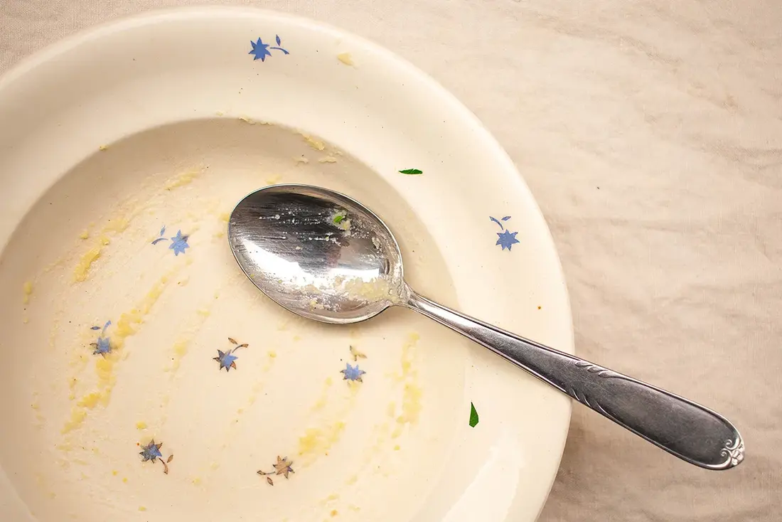 Teller mit Polenta-Resten und Löffel