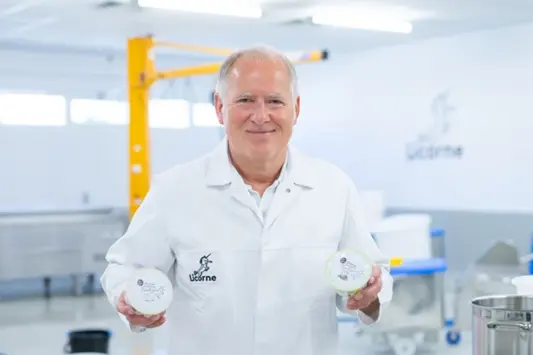 Claus Katzenberger von Licorne hält zwei Frischcremes in der Hand und blickt in die Kamera