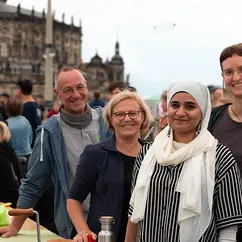 Vier Mitarbeiter:innen der VG stehen an ihrem Stand bei Dresden isst bunt und schauen in die Kamera