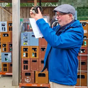 Mann hält eine Milchflasche hoch und erklärt