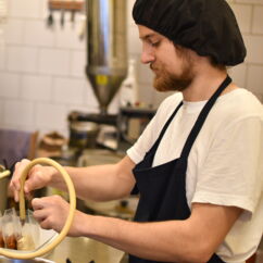 Mann füllt Beutel mit Tempeh in der Küche von Umani