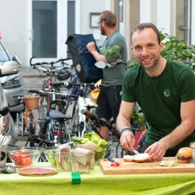 Mitarbeiter der VG Dresden steht an einem Tisch und belegt Brötchen