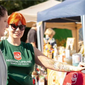 Mitarbeiterin von Mission Lifeline spricht mit Besucherin am Stand
