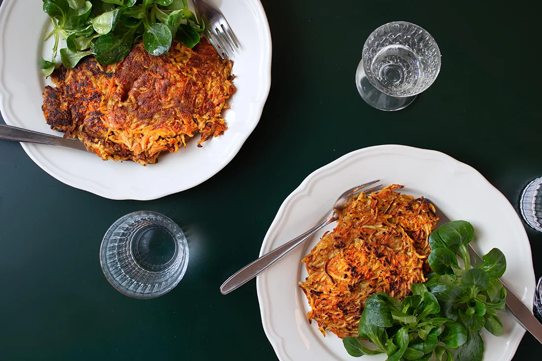 Pastinaken Karotten Rösti mit Feldsalat auf zwei Tellern