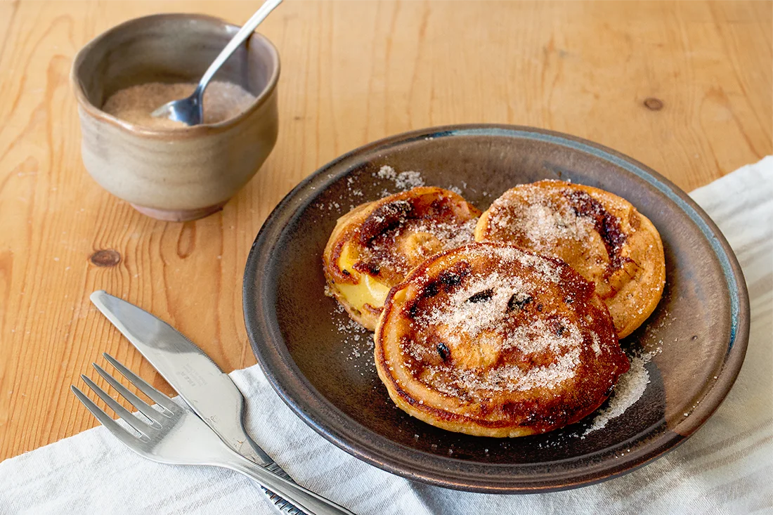Apfelküchlein auf einem Teller mit Zimt und Zucker