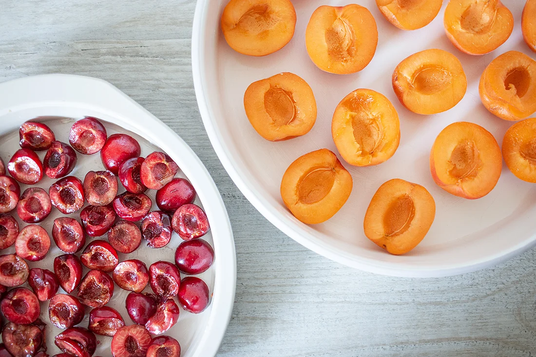Geschnittene Kirschen und Aprikosen in Kuchenformen