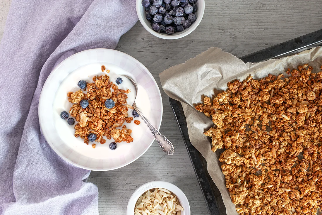 Granola selber gemacht in einer Schüssel und auf dem Backblech