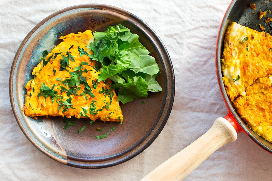 Kürbis-Frittata auf einem Teller und in einer Pfanne