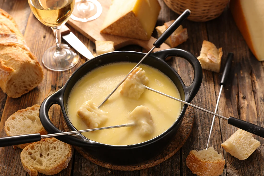 Käsefondue mit Brotstücken und Spießchen