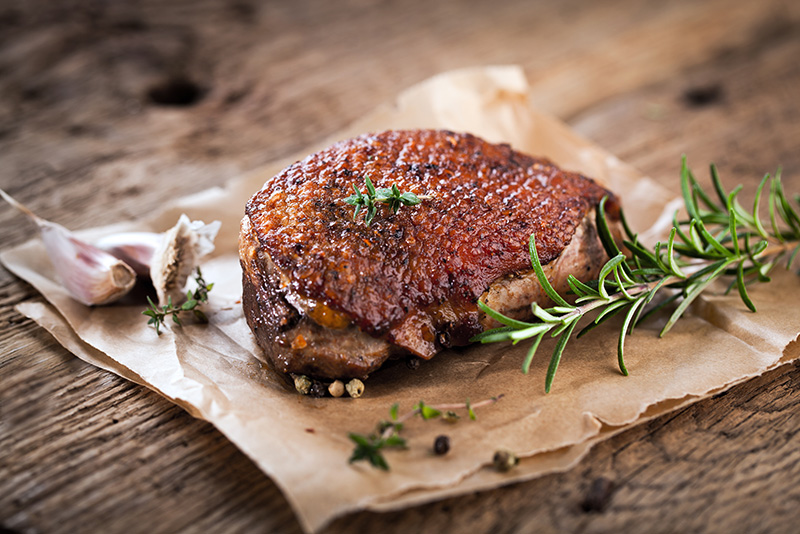 Weihnachtsbraten mit einem Rosmarinzweig