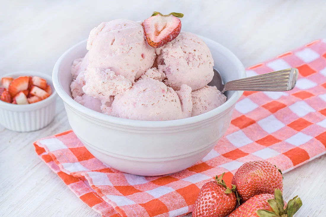 Erdbeereis mit Erdbeeren in einer Schale, mit einem Löffel. Bild: AdobeStock_Carol