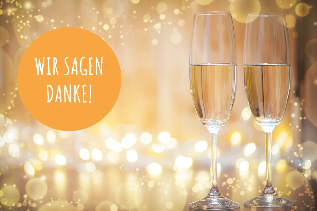 Zwei Sektgläser vor hell-gelbem Hintergrund. Text: "Wir sagen danke". Hintergrundbild: AdobeStock/depics