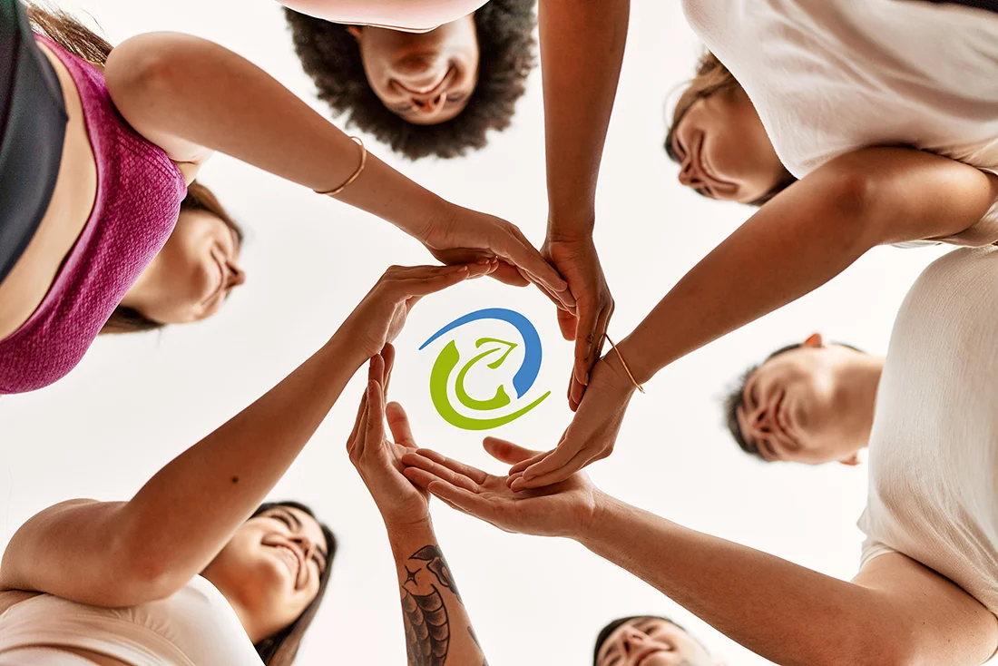 Menschen halten ihre Hände in einem Kreis. Logo der Verbrauchergemeinschaft in der Mitte. Bild: AdobeStock_Krakenimages
