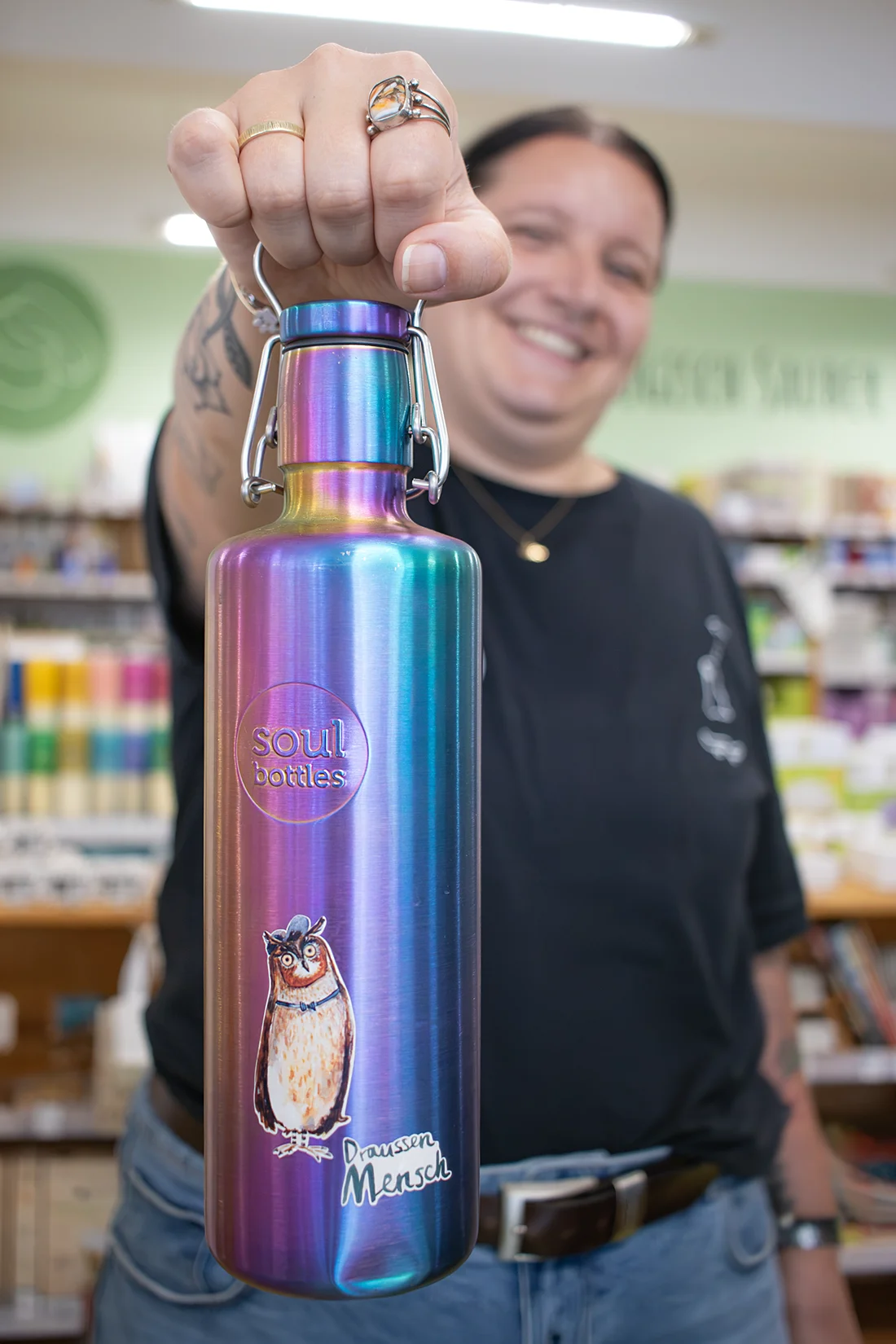 Mitarbeiterin im Naturwarenladen Dresden hält eine Trinkflasche von Soul bottles