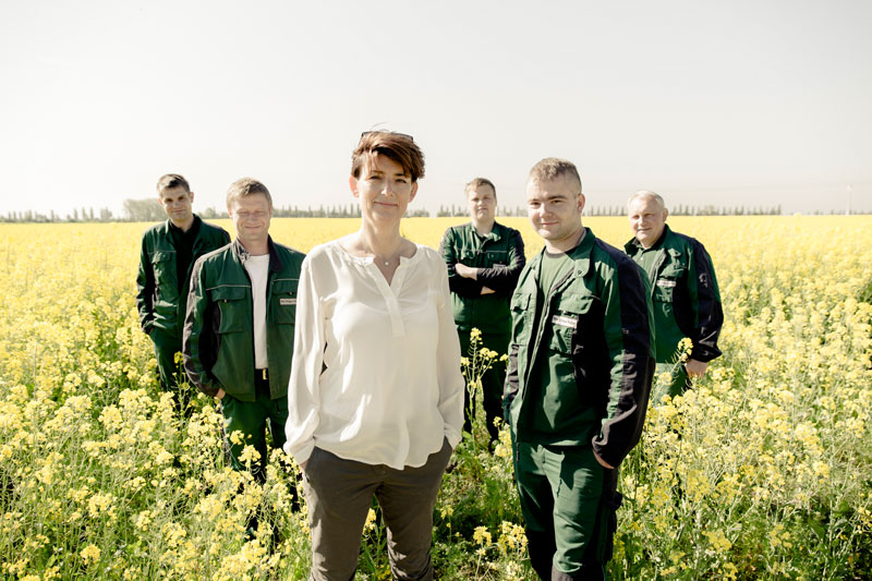 Bio-Planéte Gründerin Judtih Moog mit Bio Landwirten auf einem blühenden Rapsfeld