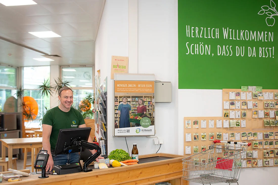 Verkäufer an der Kasse im VG Biomarkt in Dresden-Neustadt