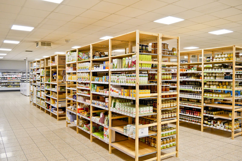 Blick auf Regalreihen mit Trockenprodukten im Innenbereich des Marktes, im Vordergrund ein Regal mit Nahrungsergänzungsmitteln