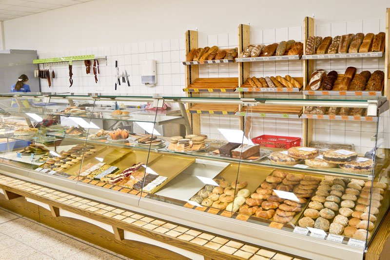 Backstation im Laden mit Auswahl süßer Teilchen, Kuchen und Broten von Bio-Bäckern