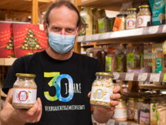 Unverpackt und Mehrweg in der VG Dresden Mitarbeiter der Verbrauchergemeinschaft Dresden zeigt zwei Gläser mit Produkten von Unverpackt für Alle
